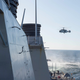 A Russian Ka-27 hovers off the stern of the USS Donald Cook while operating in the Baltic Sea